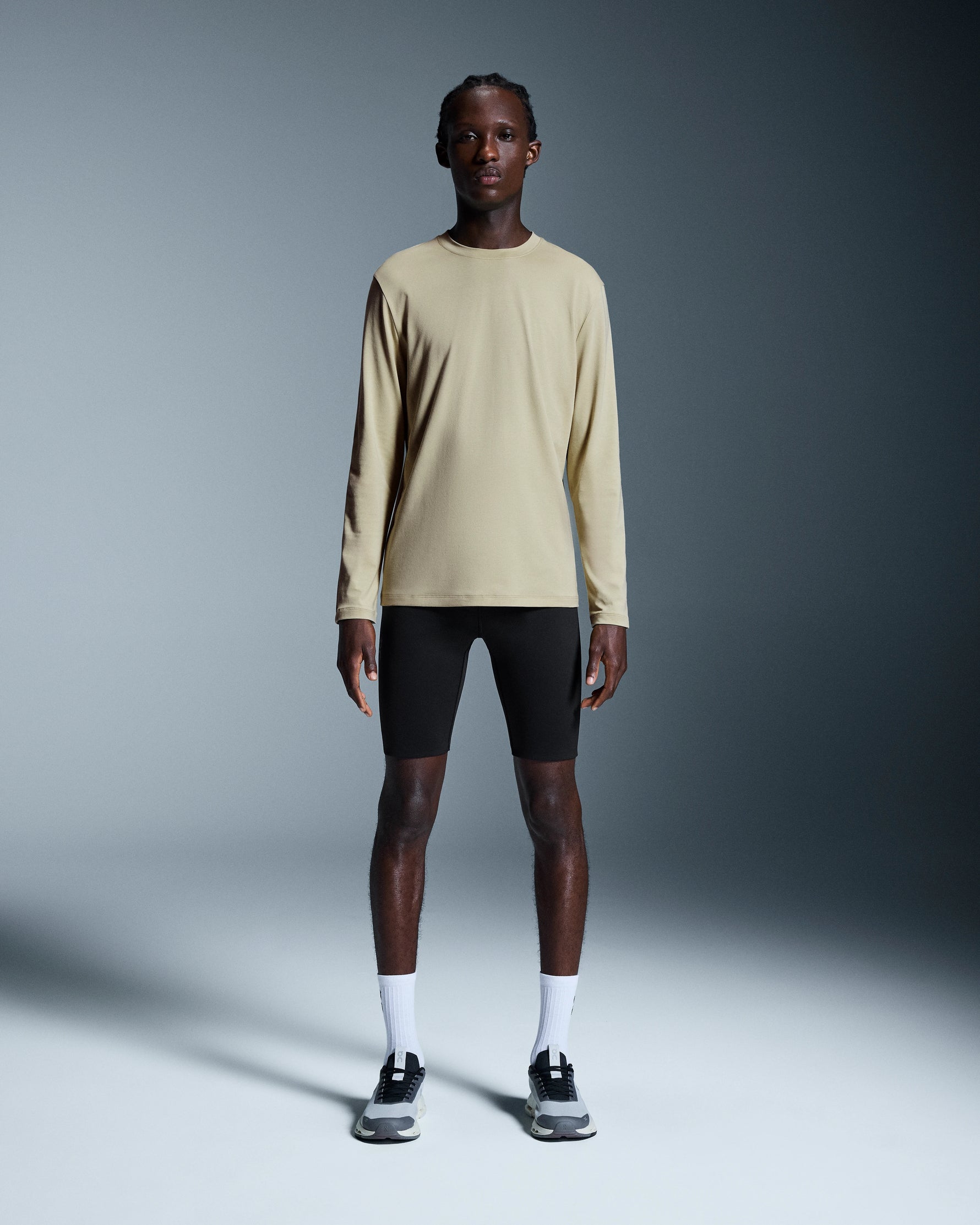 Man wearing beige On Focus-T long-sleeve shirt with black shorts and sneakers