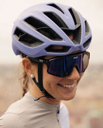 Woman wearing lavender Kask Protone Icon cycling helmet with sunglasses outdoors