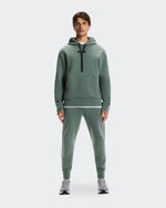 Male model wearing sage green On Focus Tech Hoodie and matching joggers