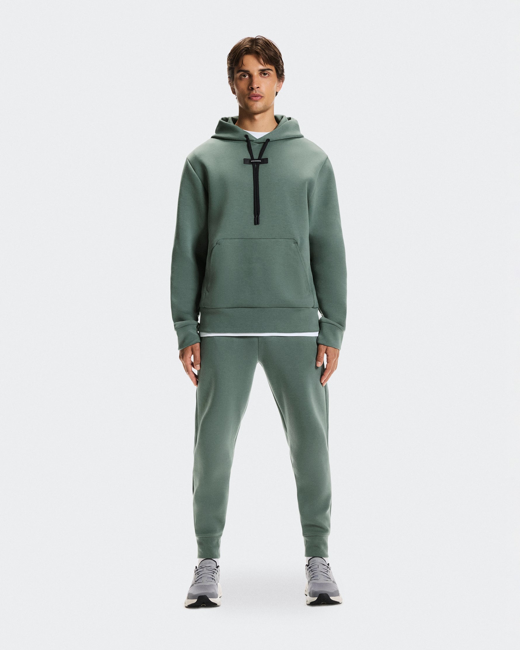 Male model wearing sage green On Focus Tech Hoodie and matching joggers