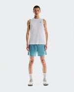 Male model wearing On 5 inch Core Shorts in Niagara blue with white tank top