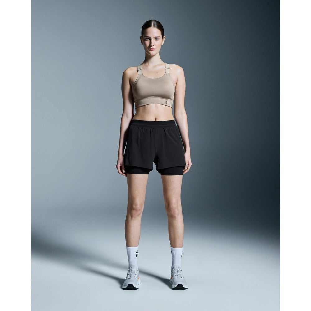 Woman wearing black On Performance 2-in-1 shorts with compression liner and sports bra