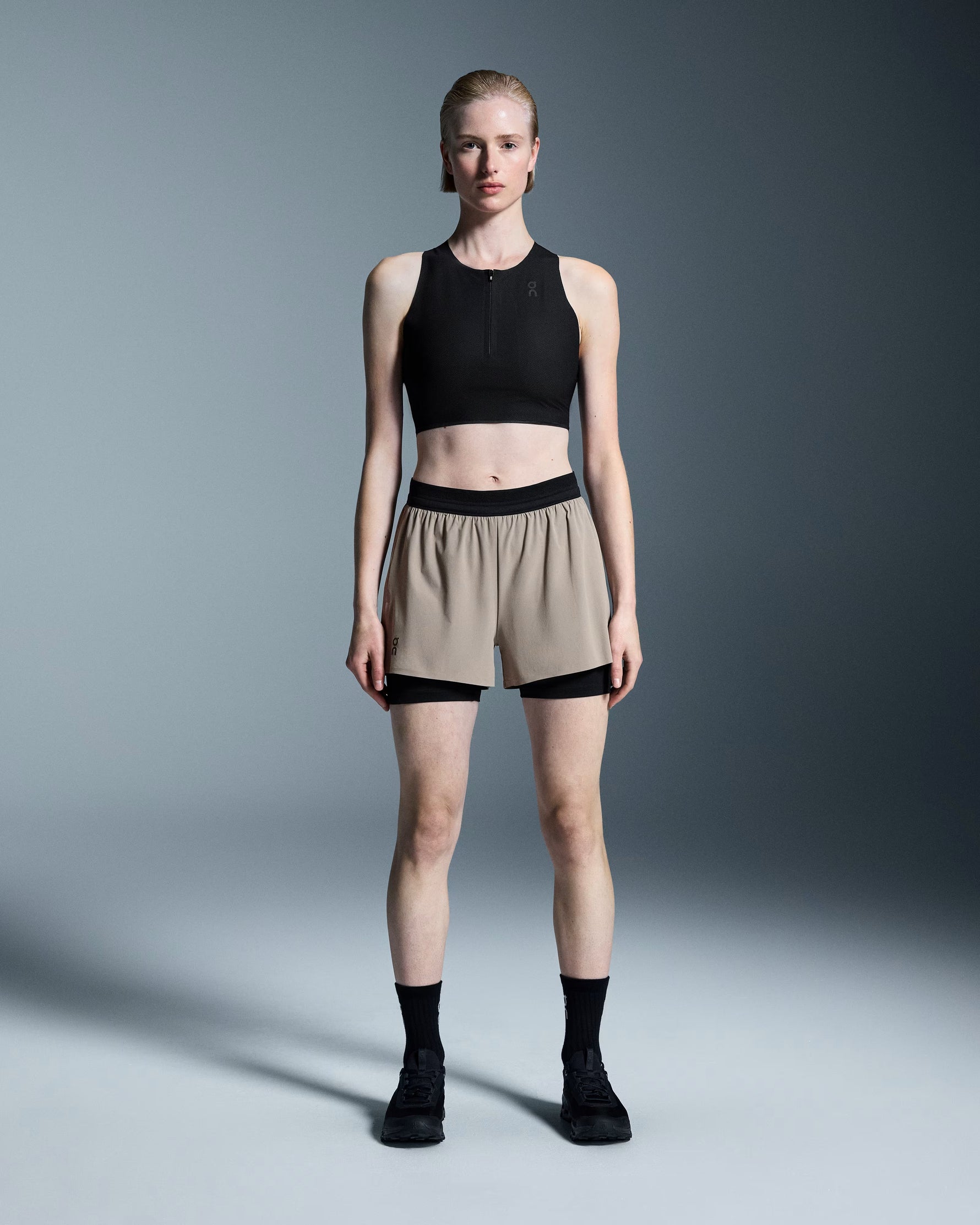Woman wearing On 3 Performance 2/1 Shorts in cinder with black waistband