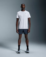 Man wearing On 7 inch Core Shorts in navy blue with white t-shirt
