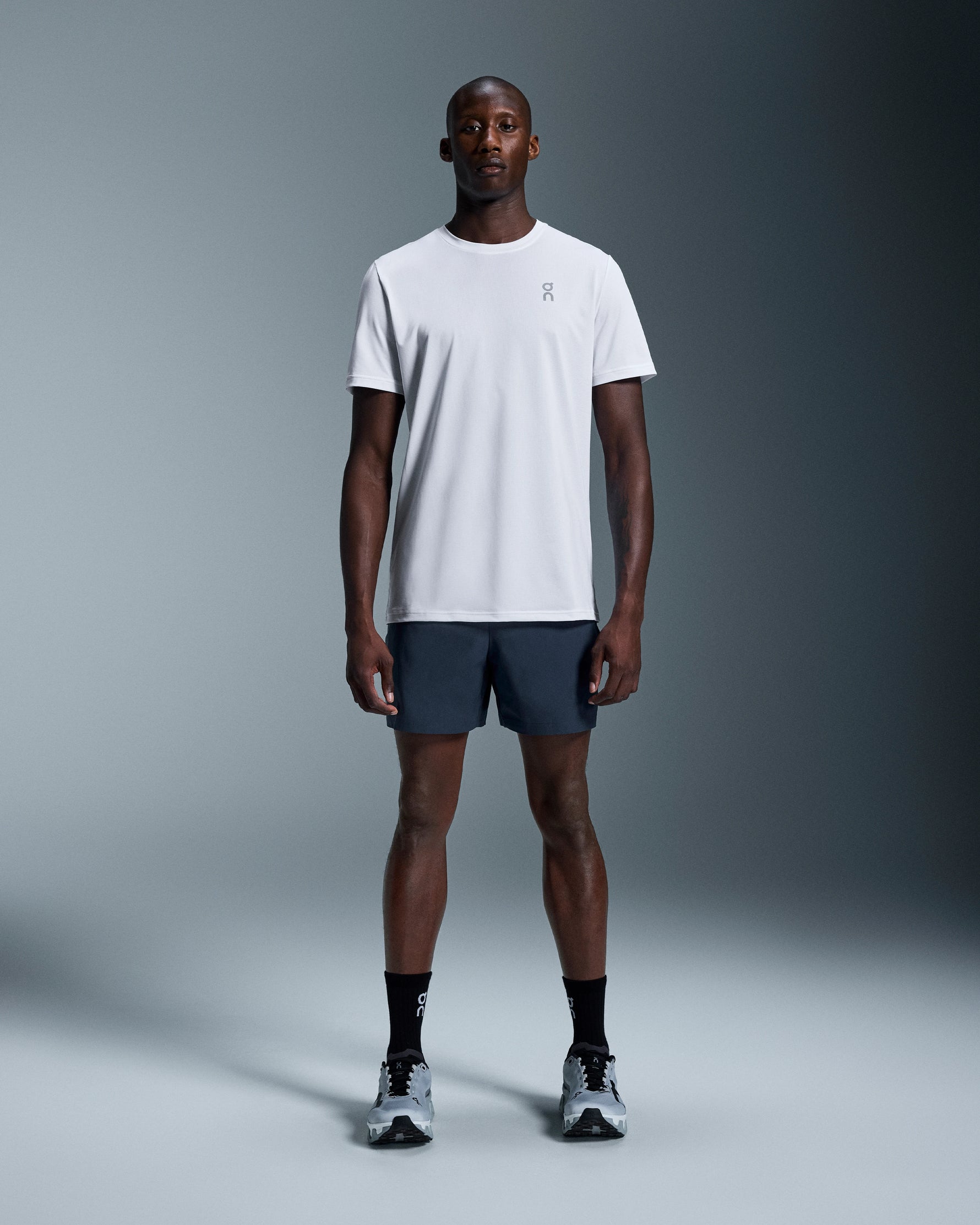 Man wearing On 7 inch Core Shorts in navy blue with white t-shirt