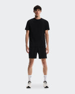 Man wearing black On Focus-T shirt and shorts with white socks and sneakers