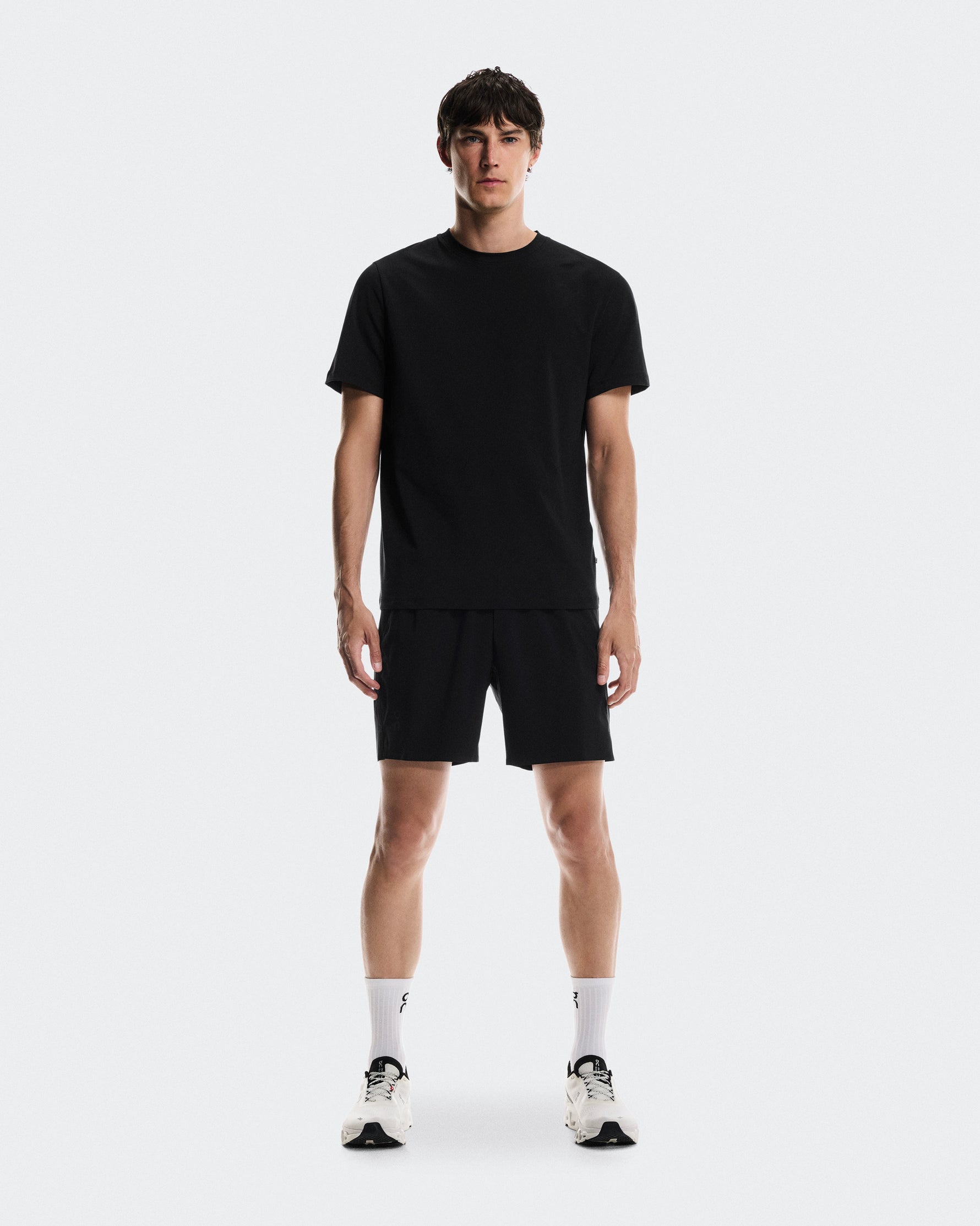 Man wearing black On Focus-T shirt and shorts with white socks and sneakers