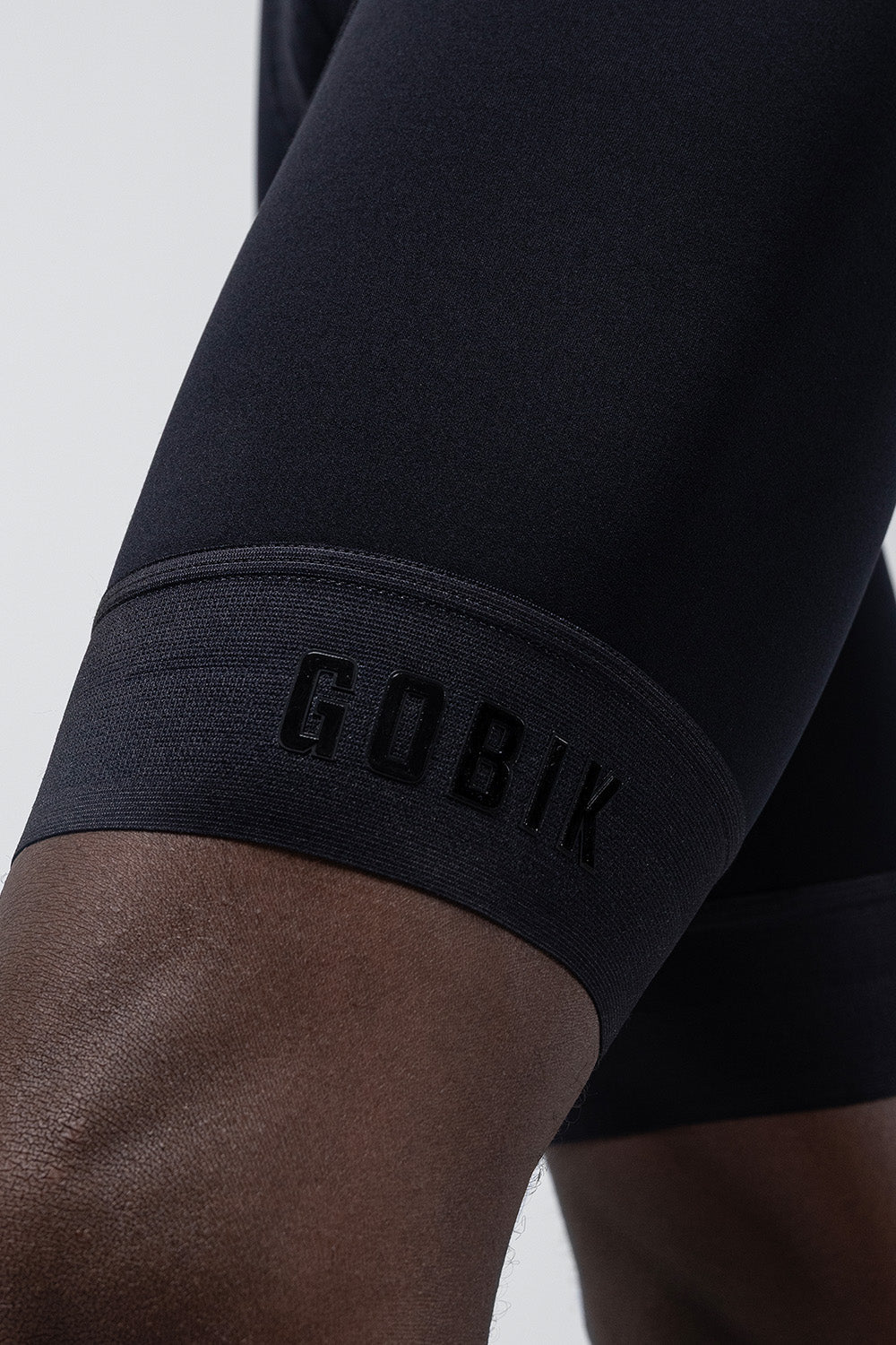 Close-up of black GOBIK cycling bibshort leg with brand name on hem