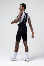 Male cyclist modeling Gobik Absolute 7.0 black bib shorts with white mesh straps
