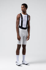 Male model wearing white Gobik Lancer bib shorts with black straps and mesh base layer