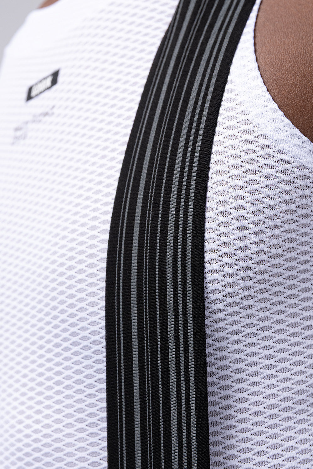 Close-up of white Gobik Lancer bib shorts with black side stripes and mesh fabric