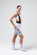 Woman wearing white Gobik INEOS Grenadiers team bib shorts with black straps