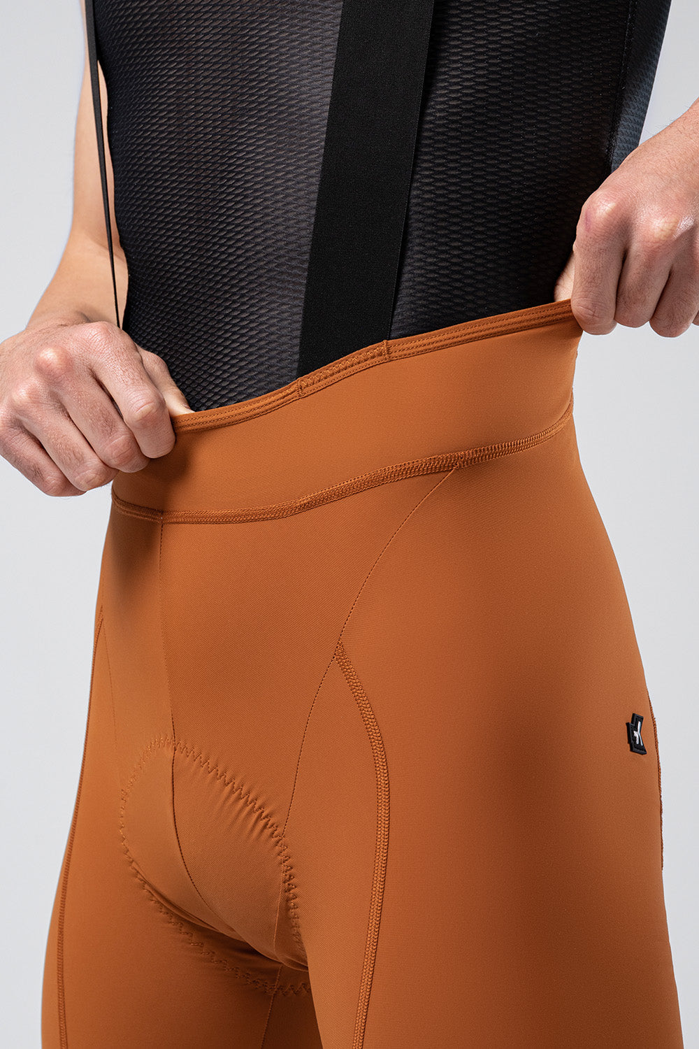Gobik Matt 2.0 bib shorts in orange showing waistband detail and professional fit