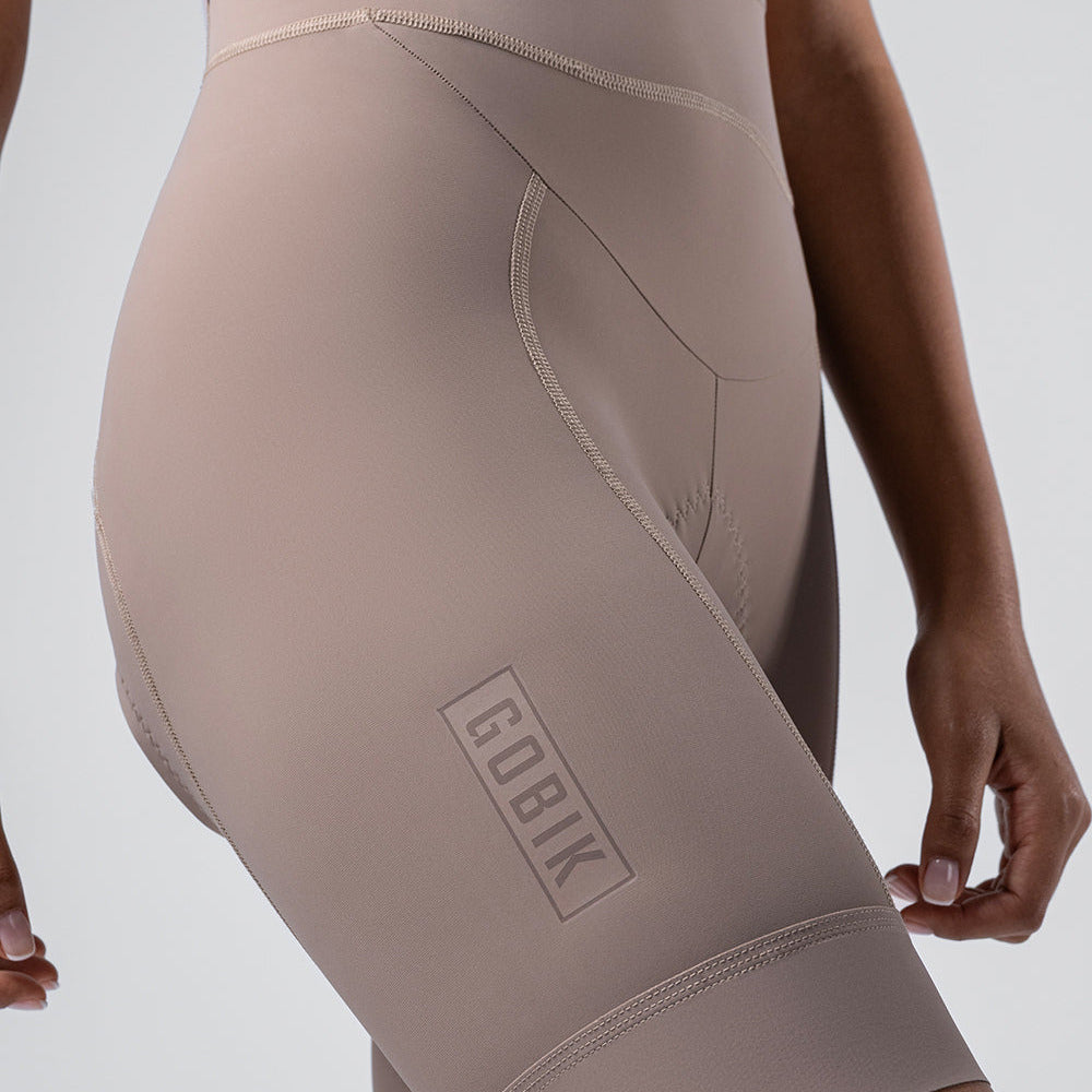 Woman wearing beige Gobik Matt 2.0 bib shorts with side pocket detail
