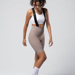 Woman wearing Gobik Matt 2.0 bib shorts in taupe with white sports bra