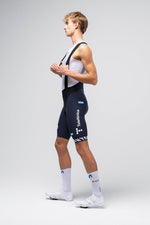 Male cyclist wearing Gobik navy blue Movistar Team bib shorts in professional studio setting