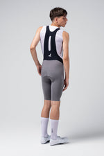 Man wearing Gobik X Bib Short in gray with white jersey, rear view