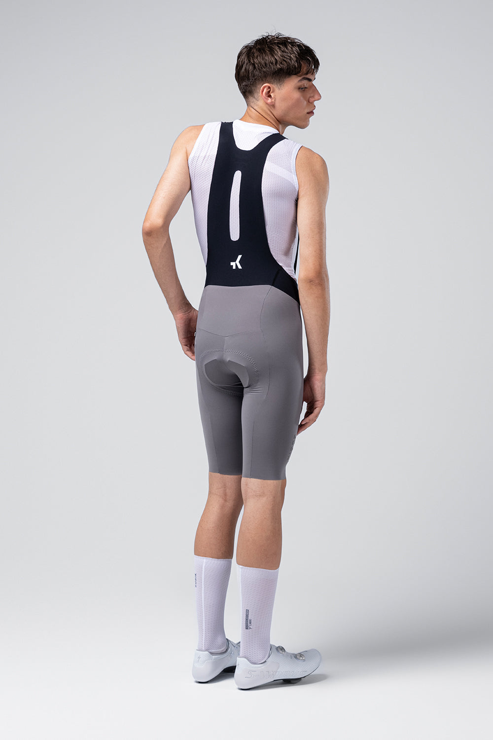 Man wearing Gobik X Bib Short in gray with white jersey, rear view