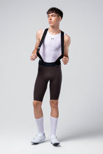 Male cyclist wearing black Gobik X bib shorts with white base layer