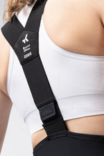 Woman wearing black Gobik X bib shorts with white tank top