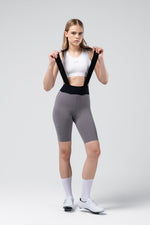 Woman wearing Gobik X Bib Short in gray with white sports bra