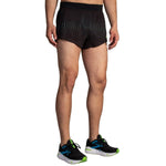 Brooks Sherpa 3-inch Split Short in Surge colorway worn by male model with matching Brooks running shoes