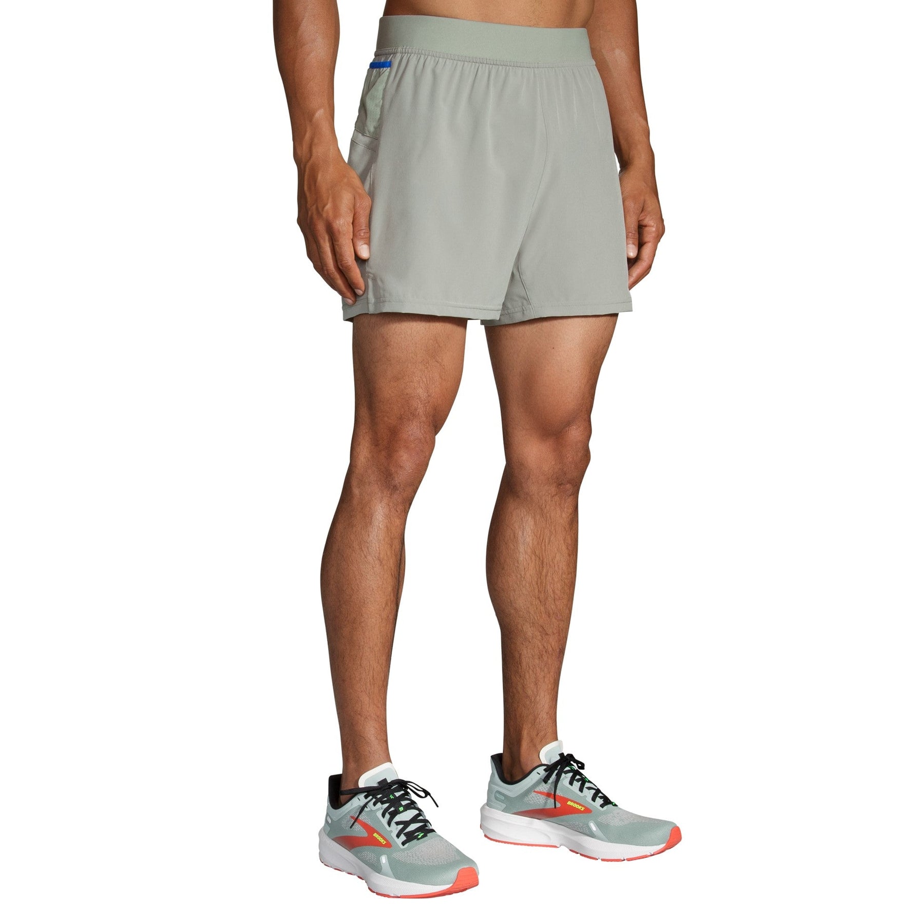 Man wearing Brooks Sherpa 5-inch running shorts in light gray with running shoes