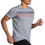 Man wearing Brooks Distance Graphic Tee in heather ash with colorful stripe design