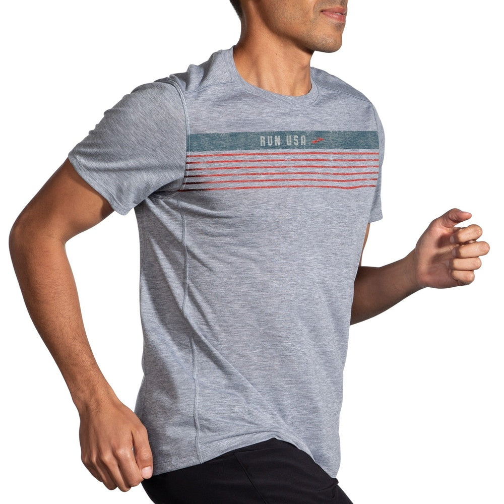 Man wearing Brooks Distance Graphic Tee in heather ash with colorful stripe design
