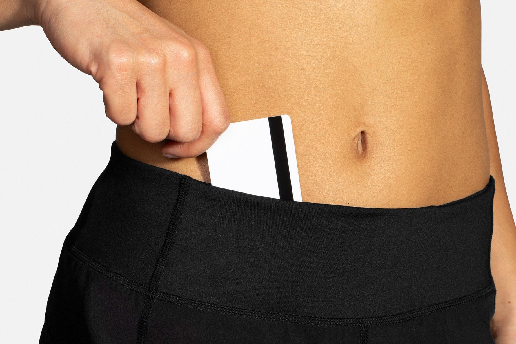 Woman wearing black Brooks Chaser 5-inch athletic shorts with phone in waistband pocket