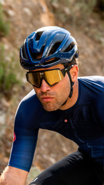 Cyclist wearing blue Kask Protone Icon helmet with gold-tinted sunglasses