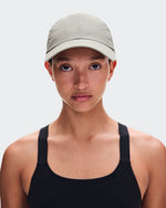 Model wearing On Cap Unisex in Brume light sage green with black athletic tank top