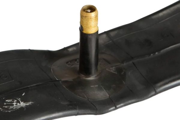 Black bicycle inner tube with brass valve stem on white background