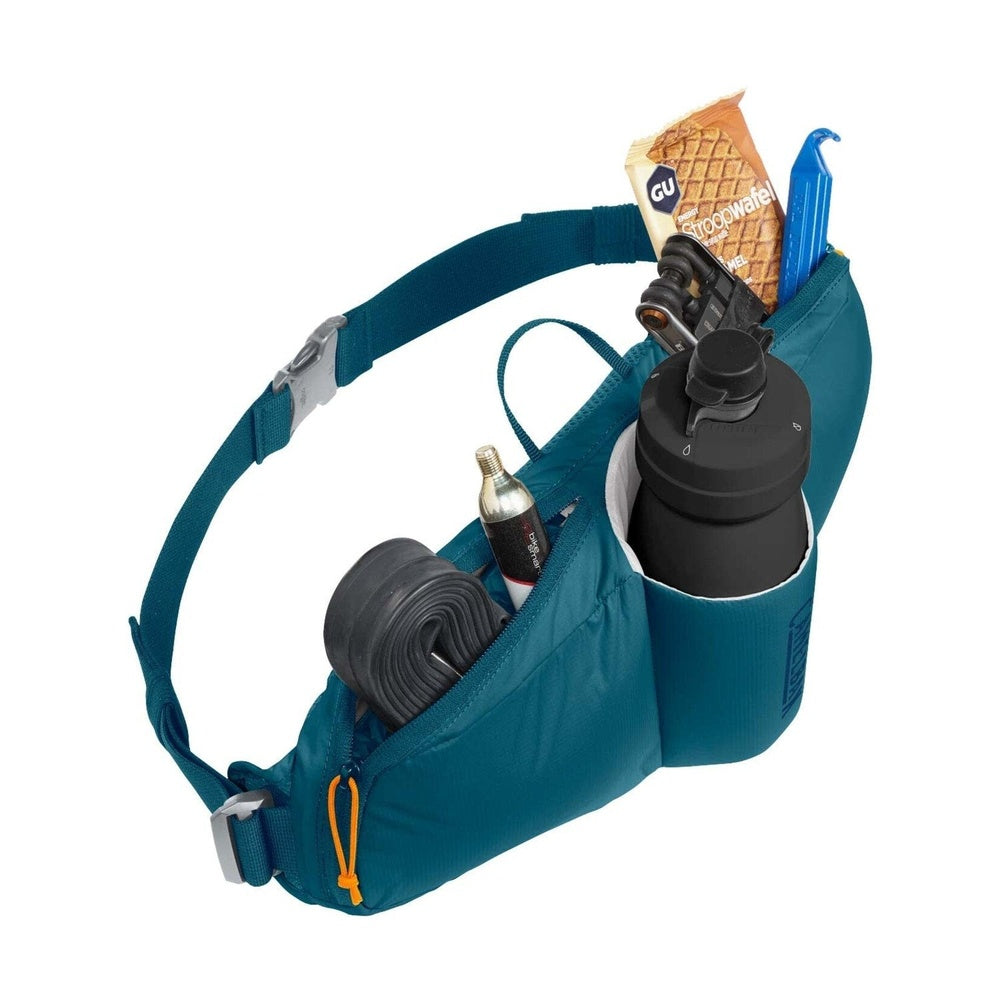 Teal CamelBak waist pack with water bottle and cycling accessories on white background
