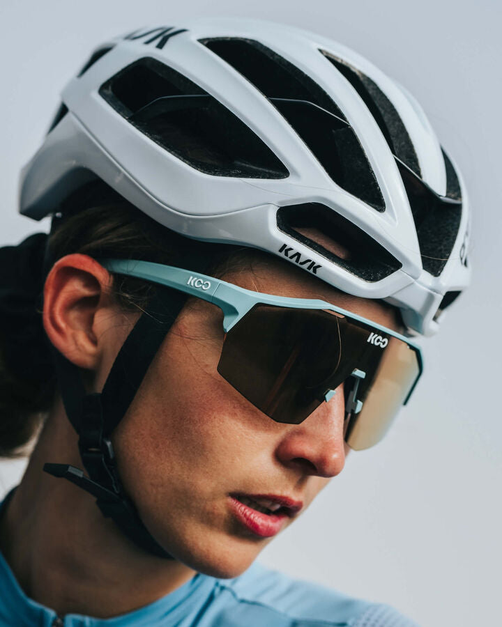 Cyclist wearing white Kask Protone helmet with sunglasses in professional lifestyle shot