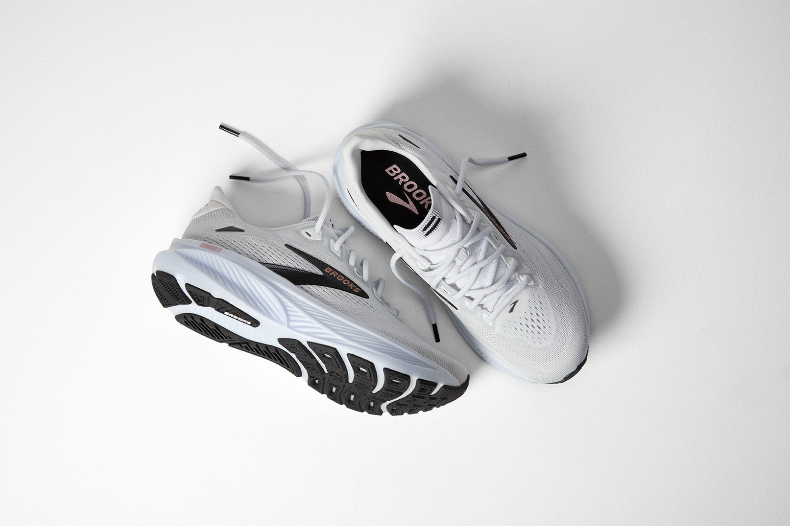Brooks running shoes in white and light gray with black accents on clean background