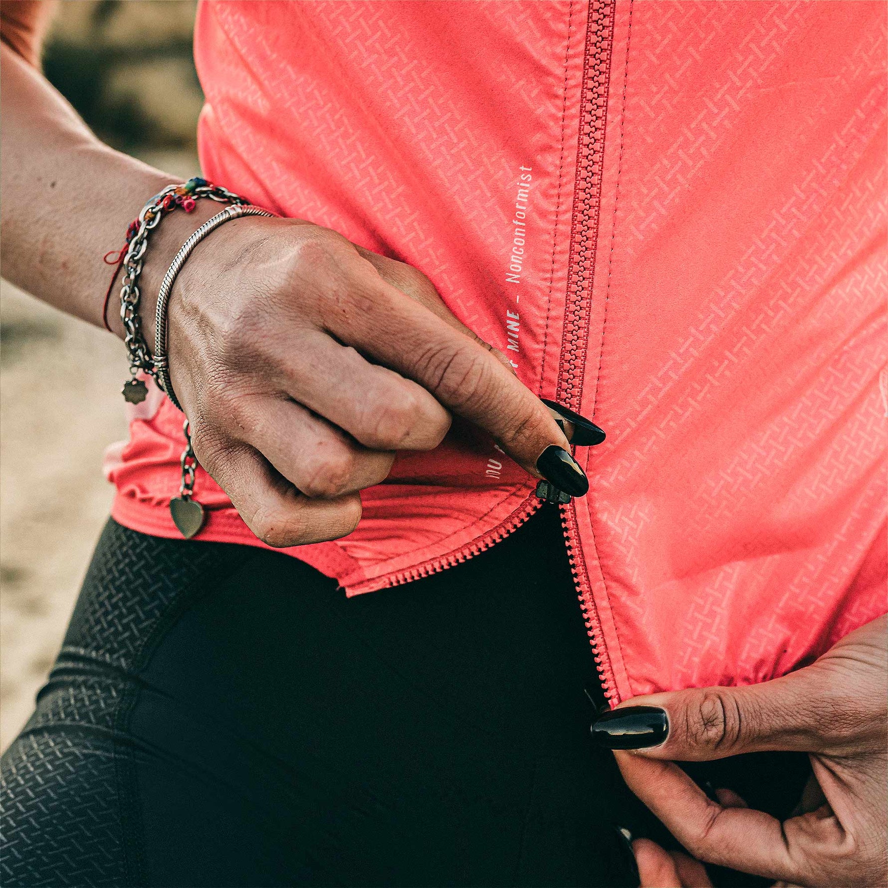 Woman wearing bright coral pink GOBIK cycling vest with zipper detail