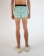 Back view of mint green running shorts with cartoon goose pattern on model