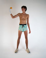 Man wearing ChicknLegs turquoise shorts with silly goose pattern and black waistband