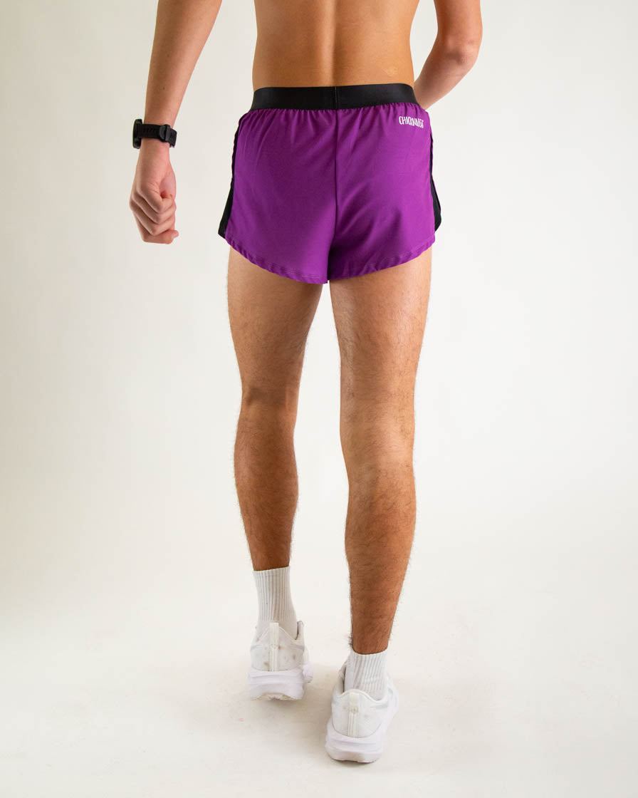 Man wearing purple running shorts with black waistband and side panels