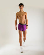 Man wearing purple Chicknlegs 2-inch split running shorts in studio