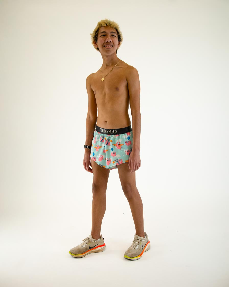 Man wearing ChicknLegs Flying Pigs split running shorts in turquoise with pink pig print