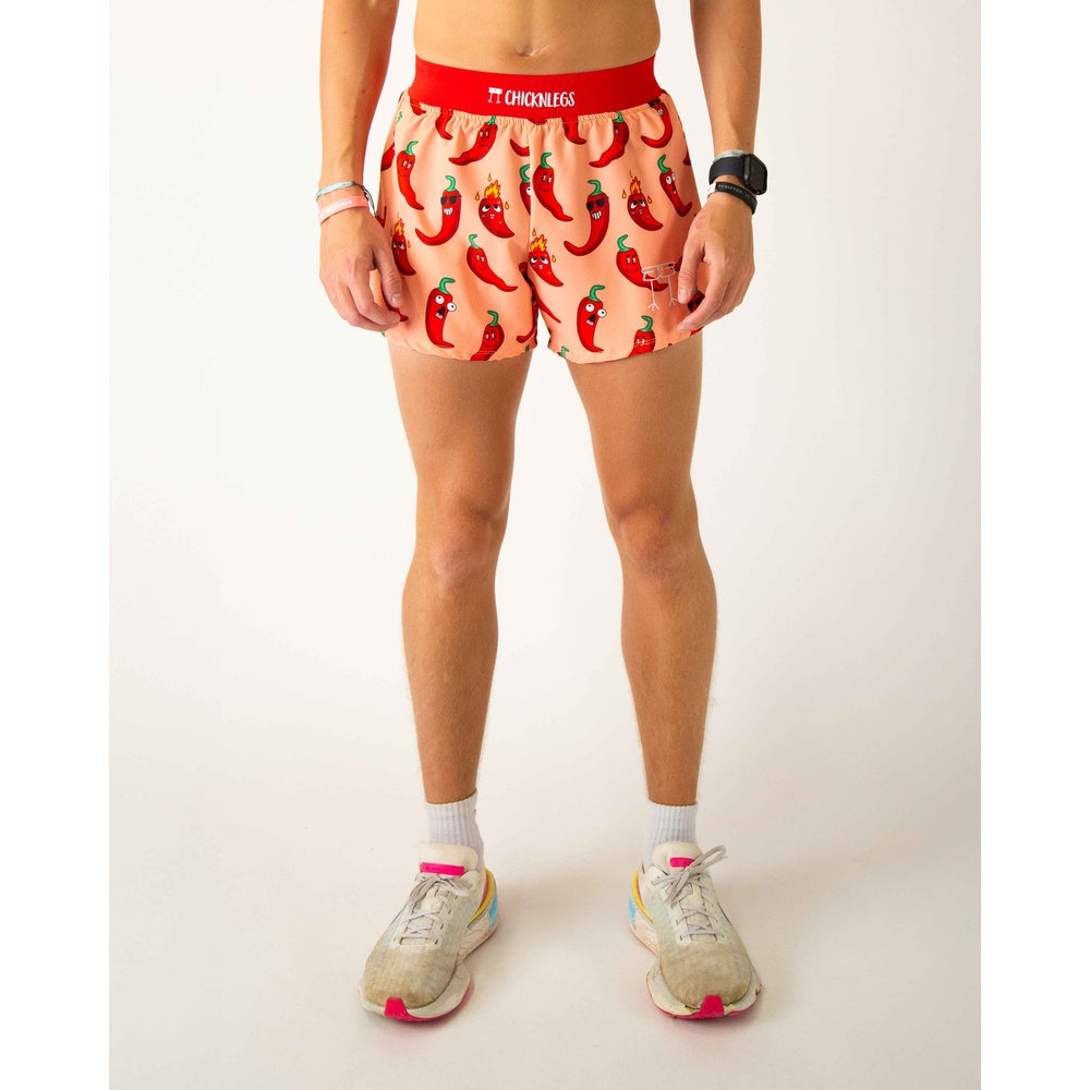 ChicknLegs men's running shorts with cartoon red chili pepper pattern on peach background
