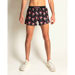 Man wearing ChicknLegs black flamingo print athletic shorts with split hem design