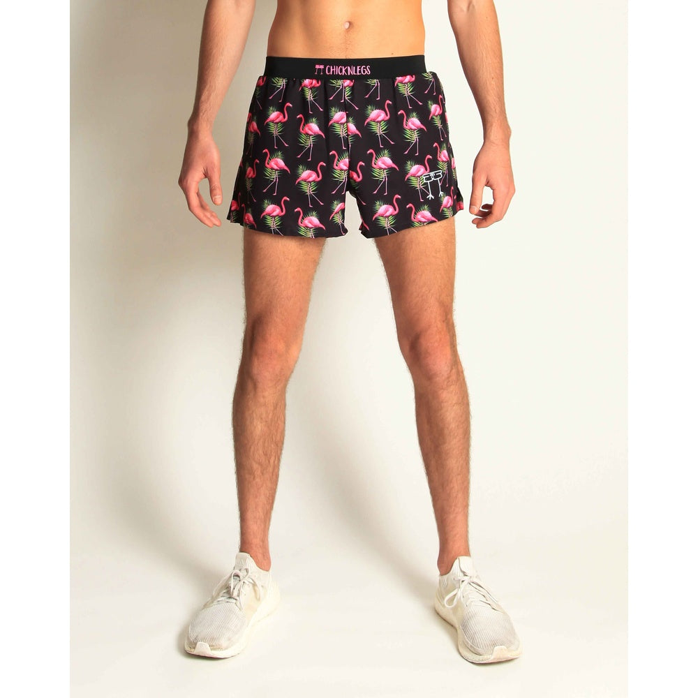 Man wearing ChicknLegs black shorts with pink flamingo and palm leaf pattern