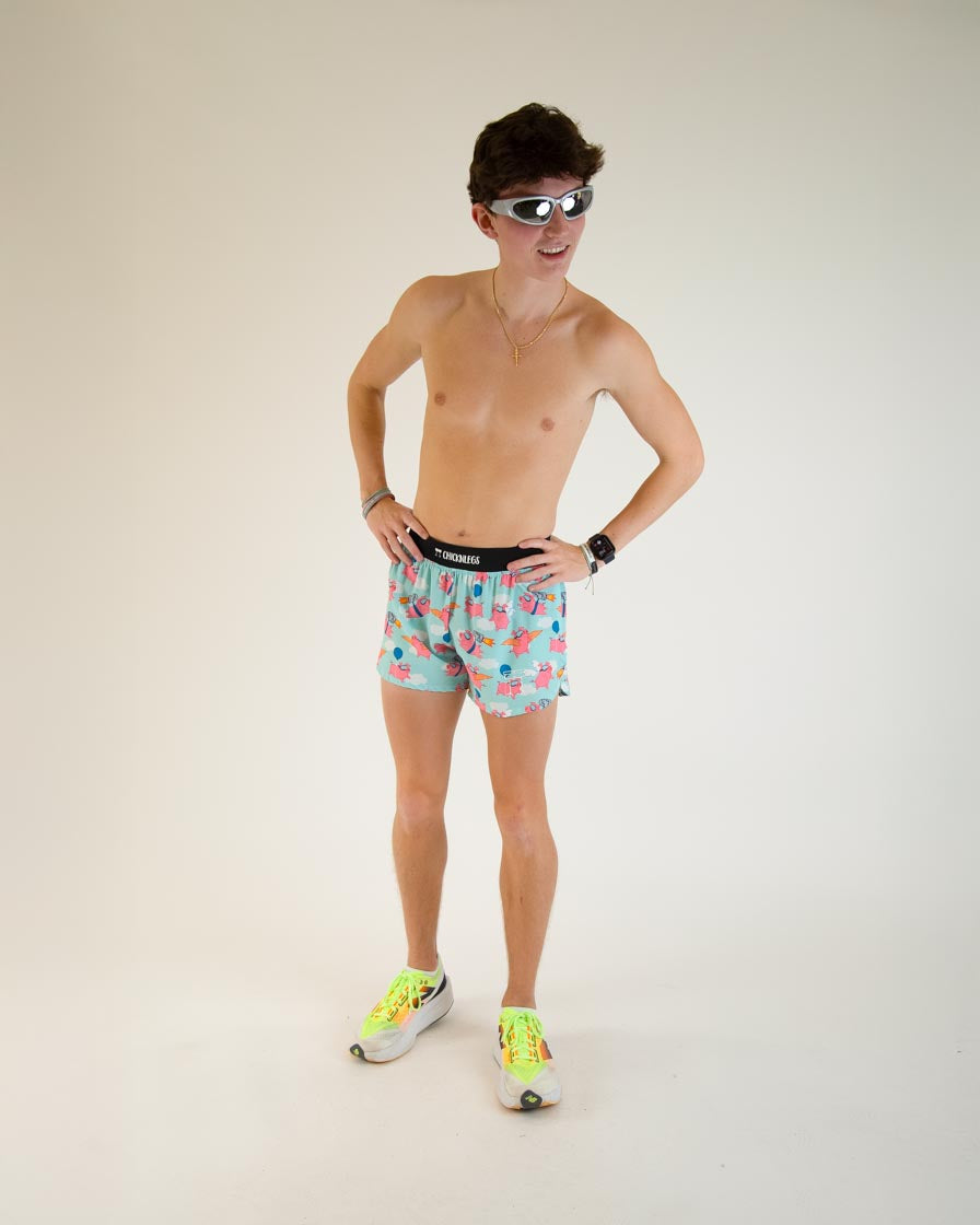 Man wearing ChicknLegs Flying Pigs 4-inch half split running shorts in aqua blue