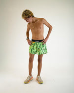 Man wearing green ChicknLegs shorts with pickle print pattern