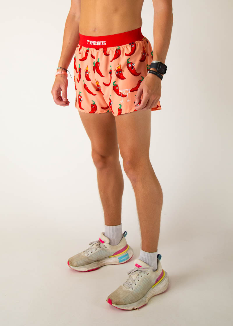 ChicknLegs men's running shorts with red chili pepper pattern on peach background