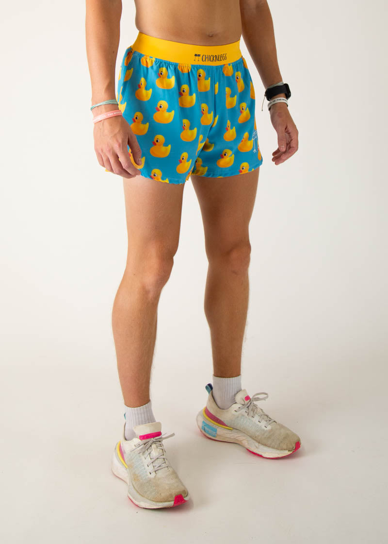 Man wearing blue ChicknLegs shorts with yellow rubber duck pattern and yellow waistband