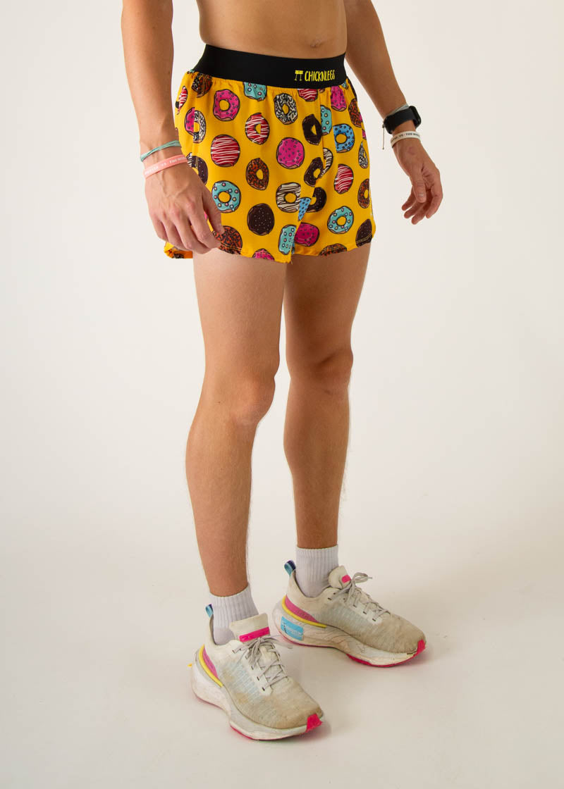ChicknLegs men's running shorts with colorful donut print on yellow background